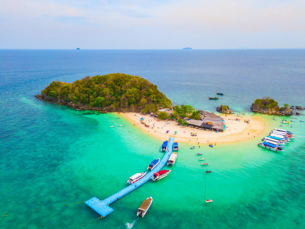 Aerial view of beach at Koh Khai, a small island, with crowd of people, tourists, blue turquoise seawater with Andaman sea in Phuket island in summer, Thailand in travel trip. Nature landscape.